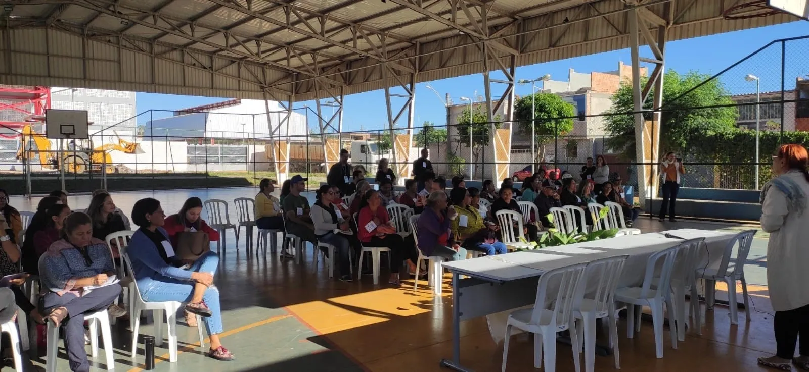 Participantes sentados em um pátio coberto durante a Conferência Livre de Assistência Social.