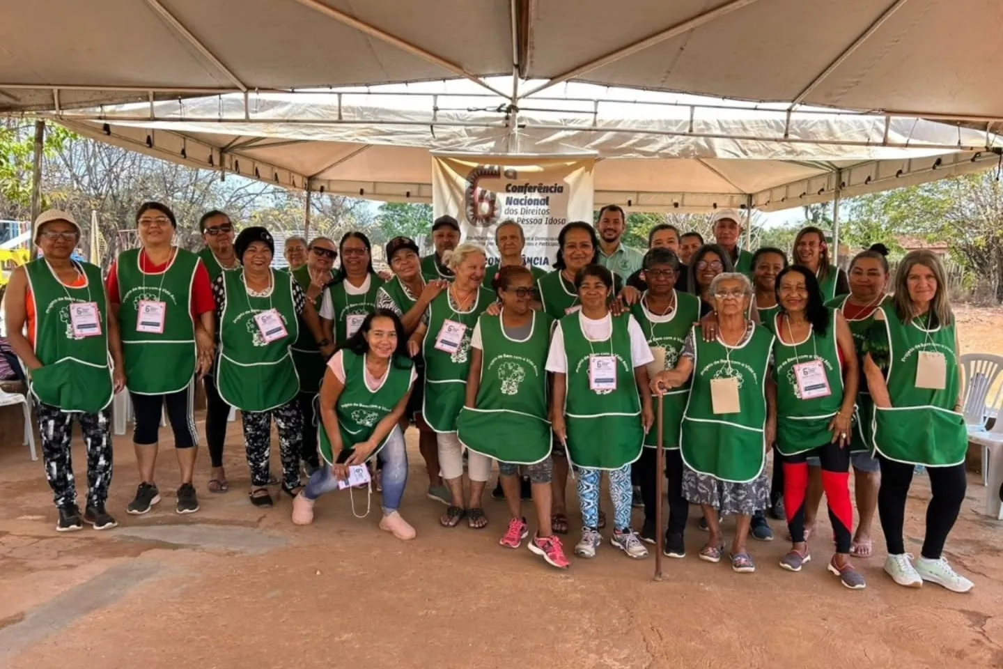 Participantes da Conferência Nacional Livre dos Direitos da Pessoa Idosa, de colete verde, reunidos sob a tenda da sede da APB.