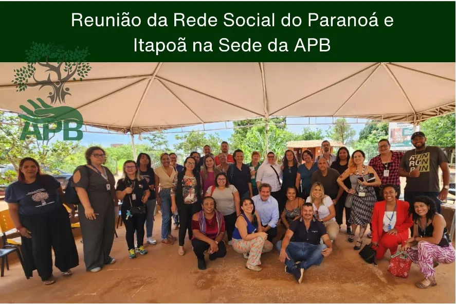 Reunião da Rede Social do Paranoá e Itapoã: grupo de adultos posando sob uma tenda, com legenda embutida na imagem.